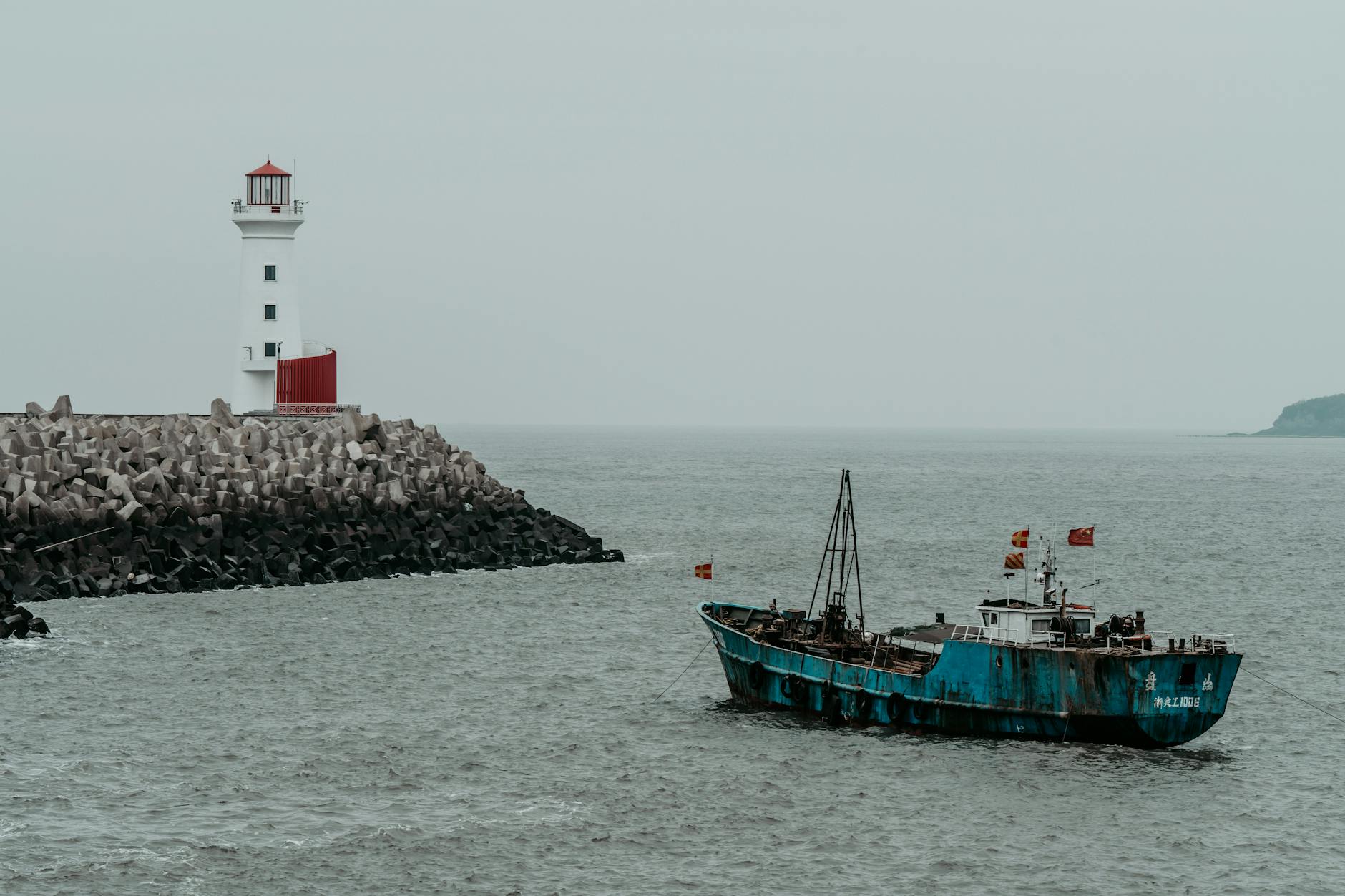 trawler near lighthouse on sea coast