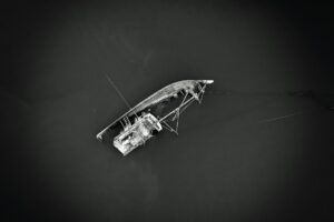 top view of a white boat wreck in a dark lake