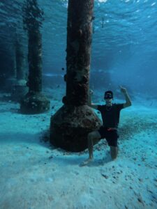 a man posing underwater on the sea floor